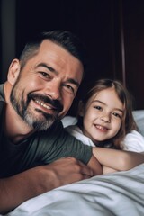 portrait of a smiling father and daughter lying together on a bed