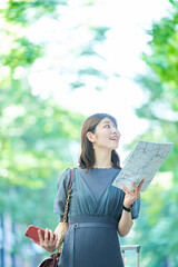 Naklejka premium 地図とスマホを手にする女性