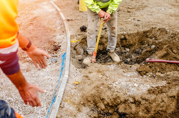 A new footpath is under construction as builders bring stone, levelling and compacting it