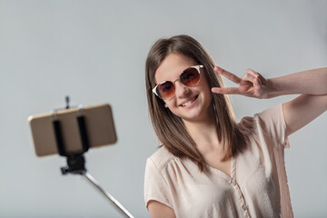 Woman in sunglasses takes selfie; aspiring influencer