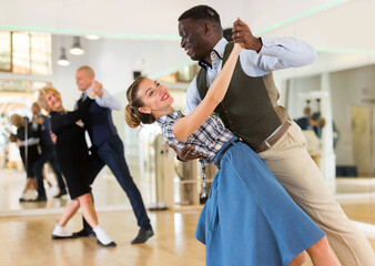 Woman with american man practising ballroom dancing - obrazy, fototapety, plakaty