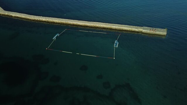 water polo field by the sea, by the concrete jetty, sunny day, summer, calm sea, view from a drone