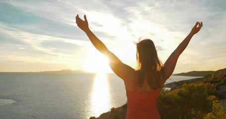 LENS FLARE, CLOSE UP: Attractive lady embraces gorgeous golden sunrise on Hvar