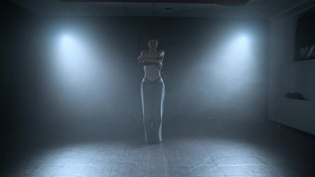 Artist performance. Graceful female dancing. Woman dancing in dark with smoke and lighting. 4K, UHD