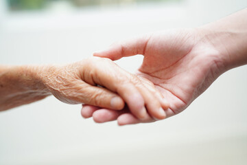 Asian young boy holding old grandmother woman hand together with love and care.