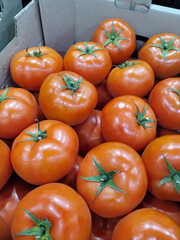 Pink tomatoes on the farmers market in a box. Vertical Orientation