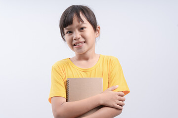 Little beautiful smiling girl holding book, going to school. close up portrait, isolated on white background, childhood. kid hugging a book. lifestyle, interest, hobby, free time, spare time
