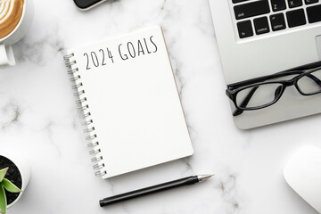 Note book with 2024 goals text on it to apply new year resolutions and plan.