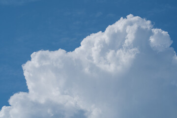 white fluffy clouds standing out against  a blue sky