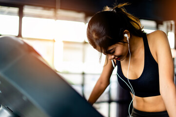 Jogging with a treadmill working out in the gym joy of running listen to music while running young...