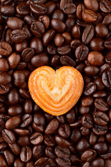 Top view of heart shape biscuit on coffee beans