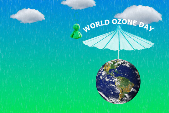 World Ozone Day text , umbrella, old rain repellent doll on natural background.Elements of this image furnished by NASA.