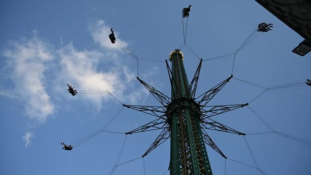 People are enjoying in the Amusement park with family members and rides during the summer evening.