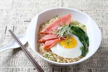 cook Japanese instant noodle mee soup with chicken ham, fried egg and vegetables on bowl chopstick on white vintage newspaper background asian chef halal food restaurant banquet menu