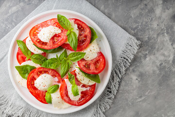 Vibrant Caprese Salad on White Plate with Gray Linen Napkin. Top View