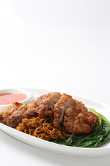 local wanton noodle mee in dark soy sauce with chicken chop cutlet, vegetables and chilli sauce in plate chopstick on white vintage newspaper background asian chef halal food restaurant banquet menu