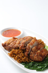 local wanton noodle mee in dark soy sauce with chicken chop cutlet, vegetables and chilli sauce in plate chopstick on white vintage newspaper background asian chef halal food restaurant banquet menu
