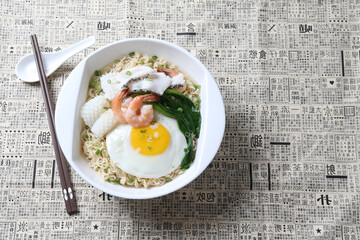 cook Japanese instant noodle mee soup with seafood fish, prawn, octopus, fried egg and vegetables on bowl chopstick on white vintage newspaper background asian chef halal food restaurant banquet menu