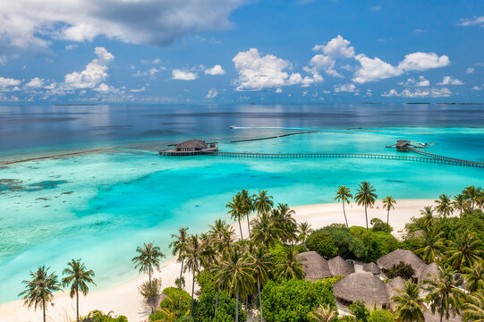Stunning aerial landscape, luxury tropical resort with water villas. Beautiful island beach, palm trees, sunny sky. Amazing bird eyes view in Maldives, paradise coast. Exotic tourism, relax nature sea