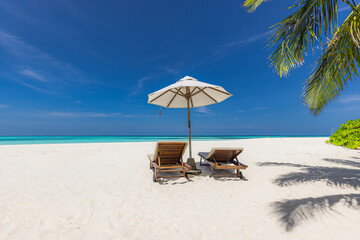 Amazing beach. Romantic chairs umbrella on sandy beach palm leaves, sun sea sky. Summer holiday, couples vacation. Love happy tropical landscape. Tranquil island coast relax beautiful landscape design