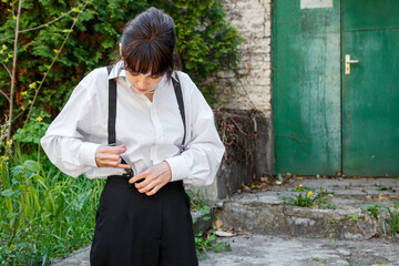Beautiful girl in a white shirt, in black trousers with suspenders