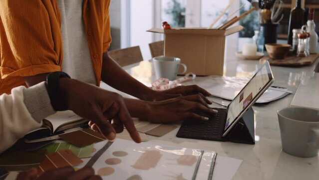 A Close Up on a Black Couple's Hands While Discussing a Design Idea