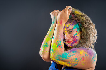 Bodypainting, creative makeup, bright colorful body art on gray background, happy plus size fat woman painted with powder paints