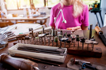 Young female jeweler making jewelry in workshop