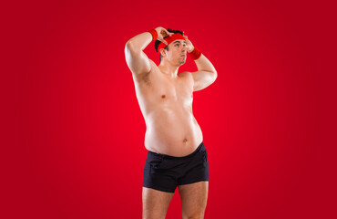 A funny fat man isolated on red background. Obesity and eating disorder. Concept for dietetics and...