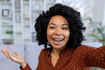 Close-up photo. Portrait of a young African American woman talking on a video call to the camera while at home