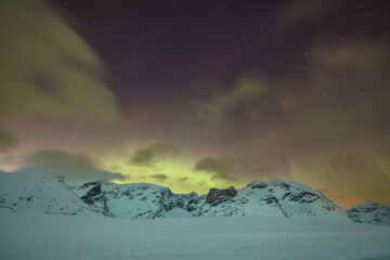 Polarlichter über verschneiten Bergen - 634347039