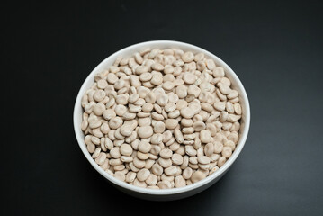 lupin dry beans on a white plate on a black background