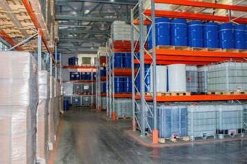 Warehouse interior. Storage company. Barrels for liquids inside warehouse. Pallet racks for storage. Barrels with substances for production. Storage area with boxes. Warehouse without people
