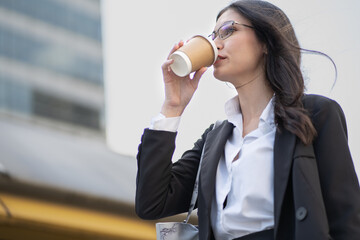 Confident businesswoman enjoy drinking as walking one person to office. Female startup entrepreneur...