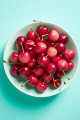 Top view of cherry fruits in bowls on blue background
