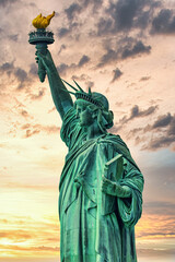 New York, New York, United States. August 07, 2023. Dramatic and detailed image of the Statue of Liberty with strong shades of green, sky with many clouds and very high resolution. - obrazy, fototapety, plakaty