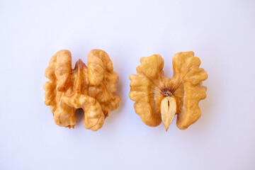 Top view of shelled walnuts cut into two pieces, two halves of walnut