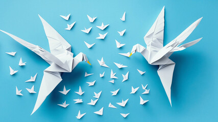 Origami birds are flying, overhead top view. White origami birds isolated on pastel blue background. - obrazy, fototapety, plakaty