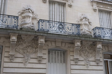 Obraz premium Fancy ornament details and decorations shot on Paris building facades. Doors and windows surround, decorated balconies.