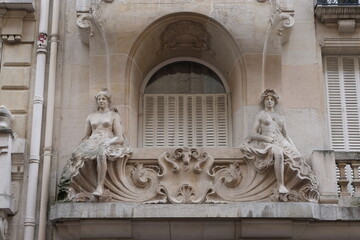 Fototapeta na wymiar Fancy ornament details and decorations shot on Paris building facades. Doors and windows surround, decorated balconies.