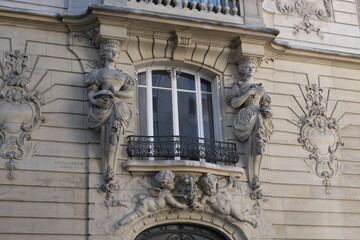 Fototapeta na wymiar Fancy ornament details and decorations shot on Paris building facades. Doors and windows surround, decorated balconies.