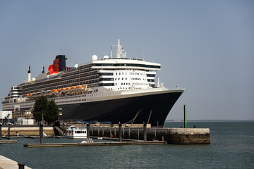 Beautiful ocean liner cruise ship docked at the port in Lisbon, Portugal. Vacation ship with a black hull. Sunny day with blue sky, space for text. - 634370866