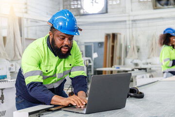 Portrait of a male engineer operating a computer, designing and controlling a machine. in the furniture industry