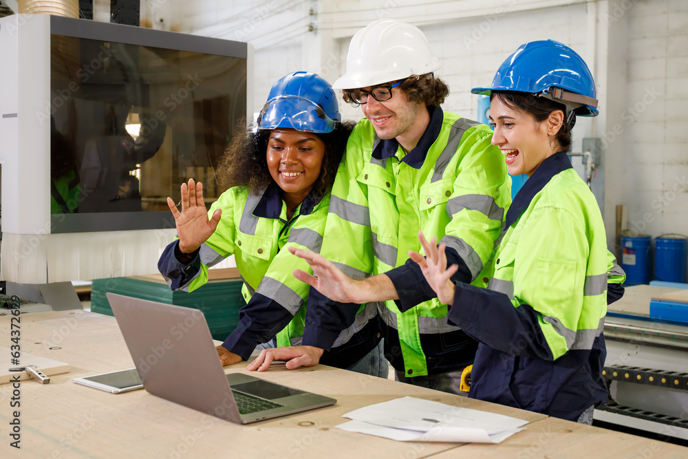 Poster portrait of a team of uniformed male engineers operating a machine with a laptop computer. in the fu