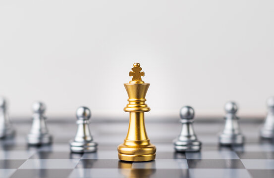 Leader, business strategy and planning concept, Gold Chess king figure on Chessboard and surrounded by a number of fallen silver chess pieces against opponent or enemy. Conflict, tactic, politic.