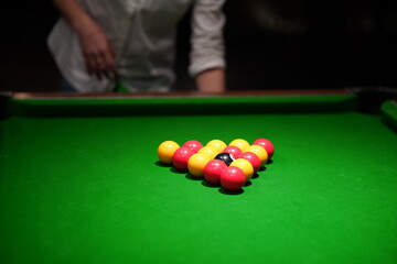 Close up of female hands racking up billiard balls.