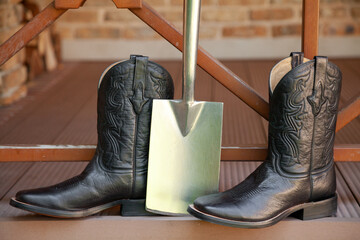 Men cowboy boots stand on veranda of ranch..