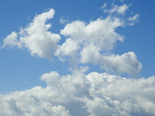 Naklejka na ściany i meble Cloudscape, background, cumulus cloud formation in a blue sky.