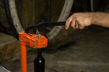 close-up of a man corking a bottle of wine at a winery