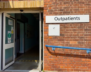 The doorway and sign at the public entrance to an outpatients department at a British hospital. 